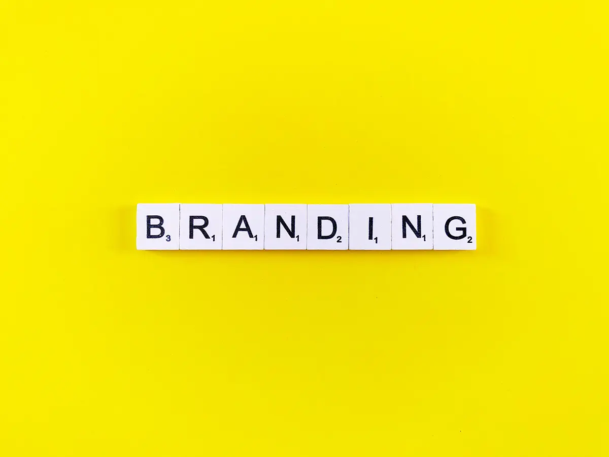 Branding spelled out with letter tiles on yellow background.